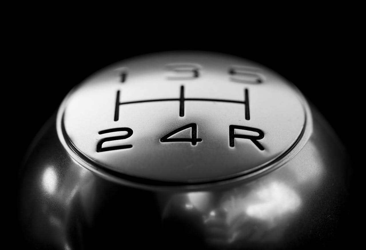 Avaleht Detailed close-up of a stainless steel gear shift knob against a black background.
